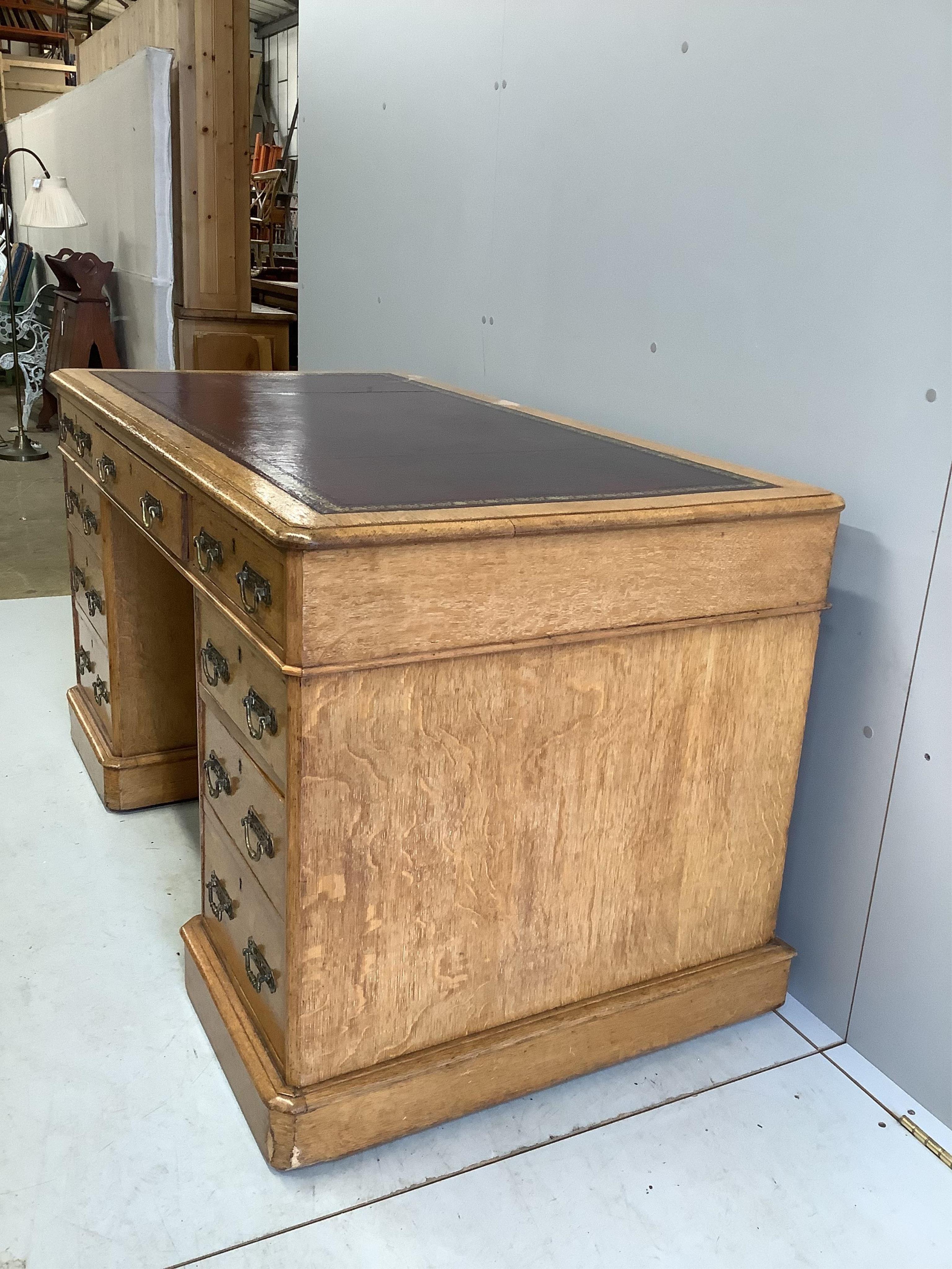 A Victorian golden oak pedestal desk, stamped E Buckham, width 136cm, depth 74cm, height 76cm. Condition - fair to good